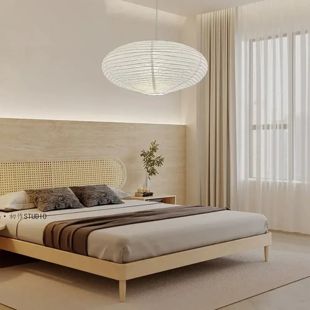 Lustre papier washi ovale blanc style japonais suspendu au-dessus d'un salon japandi