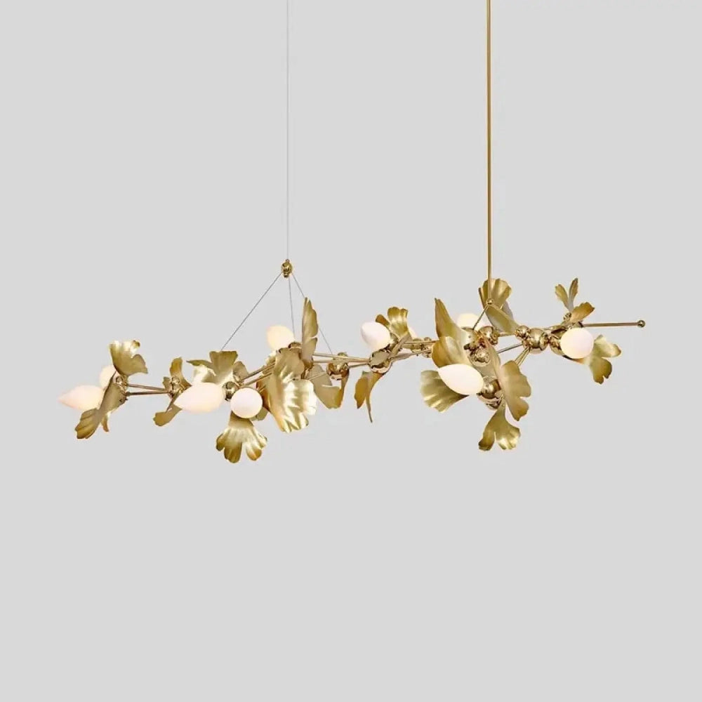 Détail branches ginkgo dorées lustre salon éclairage blanc chaud